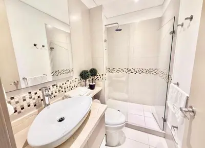 a white bathroom with a sink and a shower at 3br Apartment in front of the beach 8 paxs in Cartagena de Indias