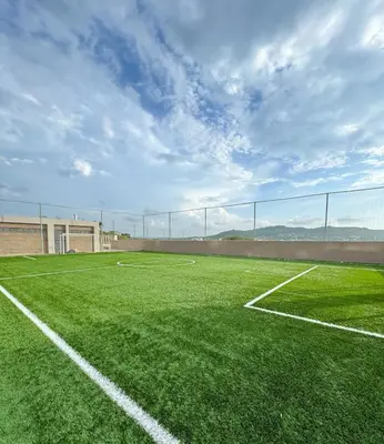 an empty soccer field with a fence in the background at refugio moderno in Barranquilla