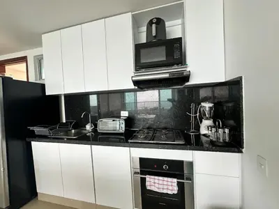 a kitchen with a stove top oven and a microwave at 2BR apartment Ocean & old city view in Cartagena de Indias