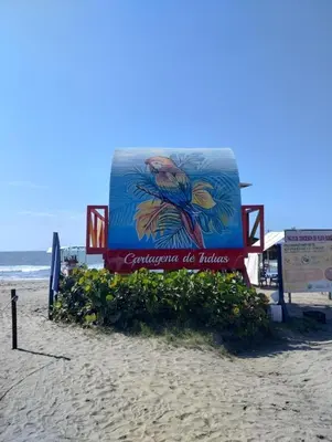 a sign on the beach next to the ocean at Apartamento completo, serena del mar, Capriella in Cartagena de Indias