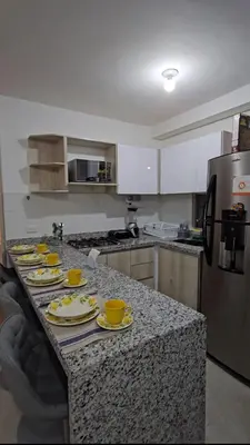a kitchen with a counter with yellow dishes on it at Apartamento completo, serena del mar, Capriella in Cartagena de Indias