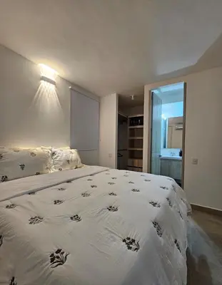 a bedroom with a large bed with a white comforter at Apartamento completo, serena del mar, Capriella in Cartagena de Indias
