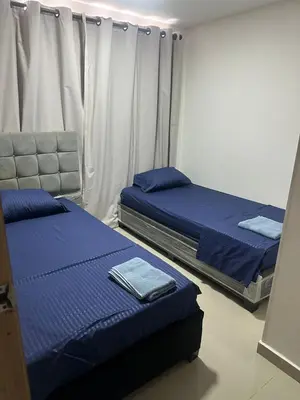 two beds in a room with blue sheets at Apartment in Barranquilla in Barranquilla