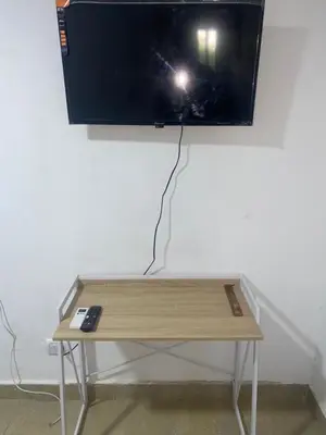 a tv hanging on a wall with a table at Apartaestudio Equipado a Menos de 100m de la Playa in Cartagena de Indias