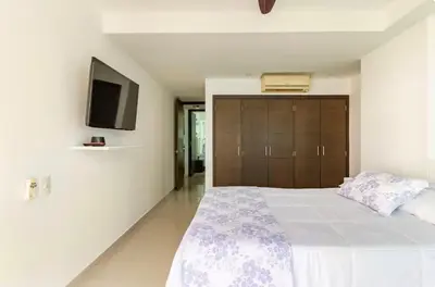 a bedroom with a bed and a tv on the wall at Espectacular Apartamento salida directa a playa in Cartagena de Indias
