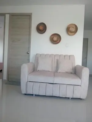 a white couch in a living room with a door at Modern & Cozy Apartment Near the Beach in Cartagena de Indias