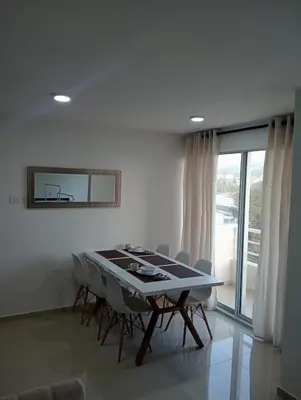 a white dining room with a table and chairs at Modern & Cozy Apartment Near the Beach in Cartagena de Indias