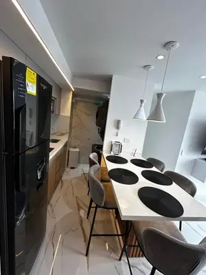 a kitchen with a table with chairs and a refrigerator at Apt 2704 in Cartagena de Indias