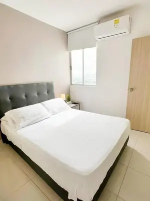 a large white bed in a room with a window at Apartamento 3 Habitaciones con Piscina cerca de las Playas de Cartagena in Cartagena de Indias