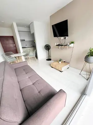 a living room with a couch and a flat screen tv at Apartamento 3 Habitaciones con Piscina cerca de las Playas de Cartagena in Cartagena de Indias