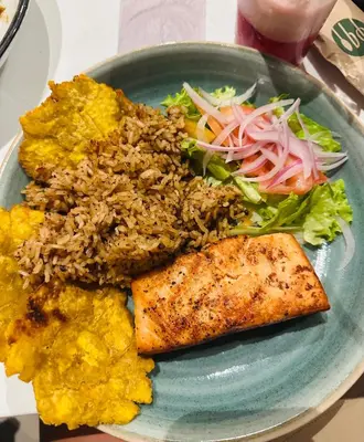 a plate of food with rice and fish and a salad at Nuevo Loft santa Marta vista al mar piso 18 in Santa Marta