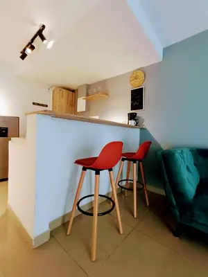 a kitchen with two red chairs and a counter at Apartamento en Cartagena cerca al Mar in Cartagena de Indias