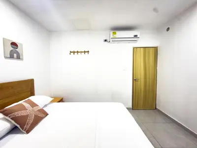 a bedroom with a white bed and a wooden door at Apartamento coral del mar in Tolú