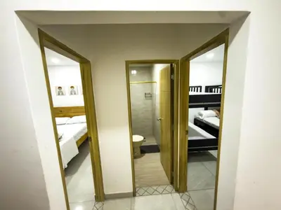 a bathroom with two mirrors and a room with two beds at Apartamento coral del mar in Tolú