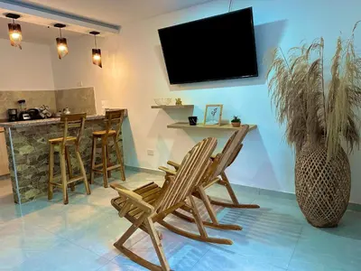 a living room with chairs and a tv on the wall at Apartamento coral del mar in Tolú