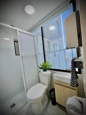 a bathroom with a toilet and a window with a plant at Vista soñada cerca al mar y centro histórico in Cartagena de Indias