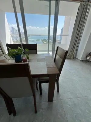 a dining table and chairs in a room with windows at Vista soñada cerca al mar y centro histórico in Cartagena de Indias