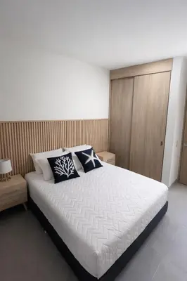 a bedroom with a white bed with two pillows on it at Apartamento en Santa Marina in Santa Marta