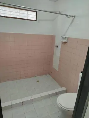 a bathroom with a toilet and a pink tiled shower at Apt at the foot of the stern in Cartagena de Indias