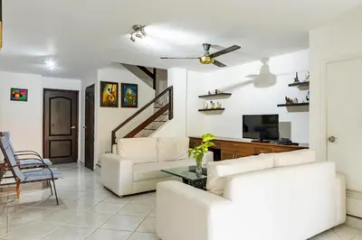 a living room with a couch and a tv at Casa en conjunto cerrado, frente al mar in Santa Marta
