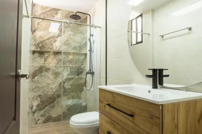 a bathroom with a toilet and a sink and a shower at Casa en conjunto cerrado, frente al mar in Santa Marta
