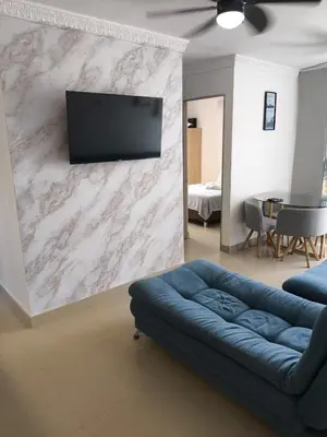 a living room with a couch and a tv on a wall at Cartagena near the beach in Cartagena de Indias