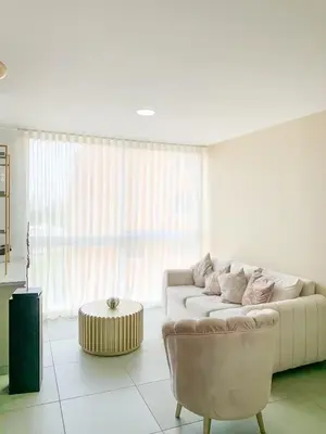 a white living room with a couch and a table at Tu Espacio Perfecto en el Norte de Barranquilla - Moderno y Amplio - Apto Dúplex in Barranquilla