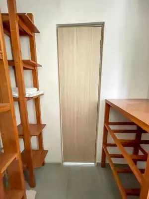 a room with a wooden door and a ladder at Tu Espacio Perfecto en el Norte de Barranquilla - Moderno y Amplio - Apto Dúplex in Barranquilla