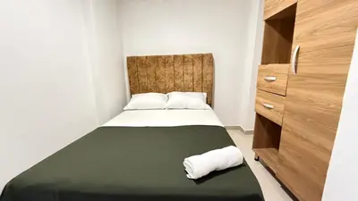 a small bedroom with a bed with a green blanket at apartamento en Canapote cerca a la playa de Marbella in Cartagena de Indias