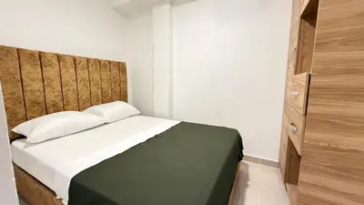 a bedroom with a bed with a wooden headboard at apartamento en Canapote cerca a la playa de Marbella in Cartagena de Indias