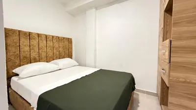 a bedroom with a bed with a wooden headboard at apartamento en Canapote cerca a la playa de Marbella in Cartagena de Indias