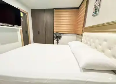 a bedroom with a white bed and a television at Tu Refugio Perfecto en el Norte de Barranquilla - Cómodo, Moderno y Central in Barranquilla