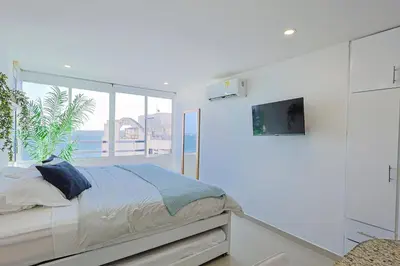 a bedroom with a bed and a large window at Riviera Loft - Apartamento con vista al mar in Cartagena de Indias