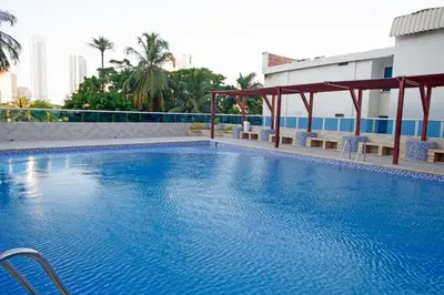 a large blue swimming pool in a building at Riviera Loft - Apartamento con vista al mar in Cartagena de Indias