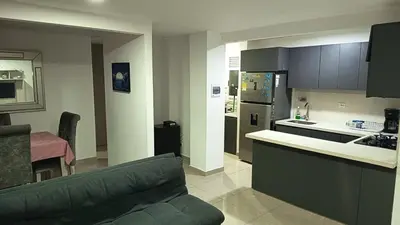 a living room with a couch and a kitchen at Apartamento Hermoso in Barranquilla