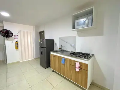a kitchen with a stove and a refrigerator at Habitación con baño privado cerca del carnaval de Barranquilla in Barranquilla