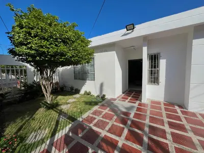 a white house with a tree in the yard at Habitación con baño privado cerca del carnaval de Barranquilla in Barranquilla