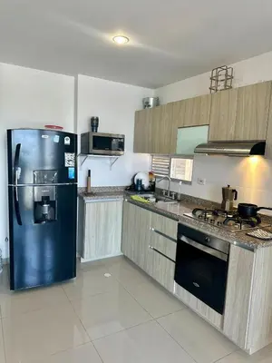 a large kitchen with a refrigerator and a stove at Confort y Estilo en el Norte de Barranquilla in Barranquilla