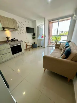 a living room with a couch and a kitchen at Confort y Estilo en el Norte de Barranquilla in Barranquilla