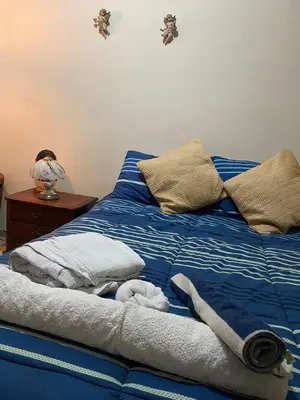 a bed with blue and white sheets and pillows at hermosa habitacion in Barranquilla