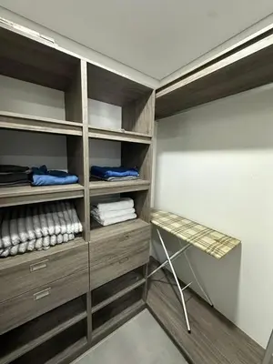a walk in closet with wooden shelves and a table at Beautiful, apartment near CC Único, Estadio R Martinez in Barranquilla