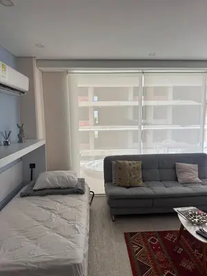 a living room with a couch and a large window at Cartagena Cielo Mar Apartment Steps from the Beach in Cartagena de Indias