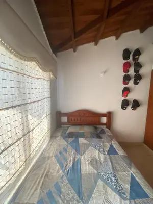 a bedroom with a bed and a window with shoes on the wall at Habitación doble en casa de conjunto cerrado in Barranquilla