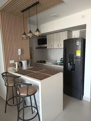 a kitchen with a black refrigerator and some chairs at loft relax con vista al mar in Cartagena de Indias