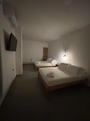 a hotel room with two beds and a television at Hotel Portón de La Sabana in San Onofre
