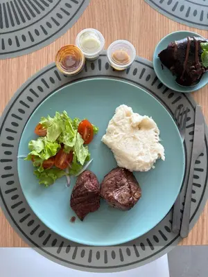 a plate of food with meat and vegetables on a table at Horizonte Infinito - Calidez frente al mar Santa Marta in Santa Marta