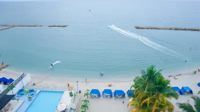 a view of a beach with chairs and a swimming pool at Magico Apartamento Frente al Mar 3 Habitaciones BM81 in Coveñas