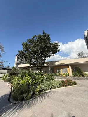 a building with a tree and plants in front of it at New apartment on the 18th floor in Santa Marta with ocean views in Simón Bolivar