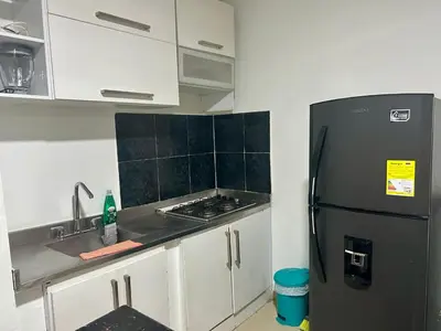 a kitchen with a black refrigerator and white cabinets at Apartamento Sol y mar Cartagena in Cartagena de Indias