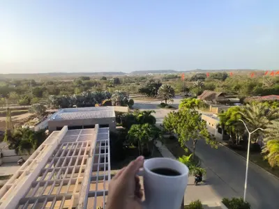 a person holding a cup of coffee in front of a building at Baía Kristal Spectacular View Crystal Clear Lagoon in Cartagena de Indias